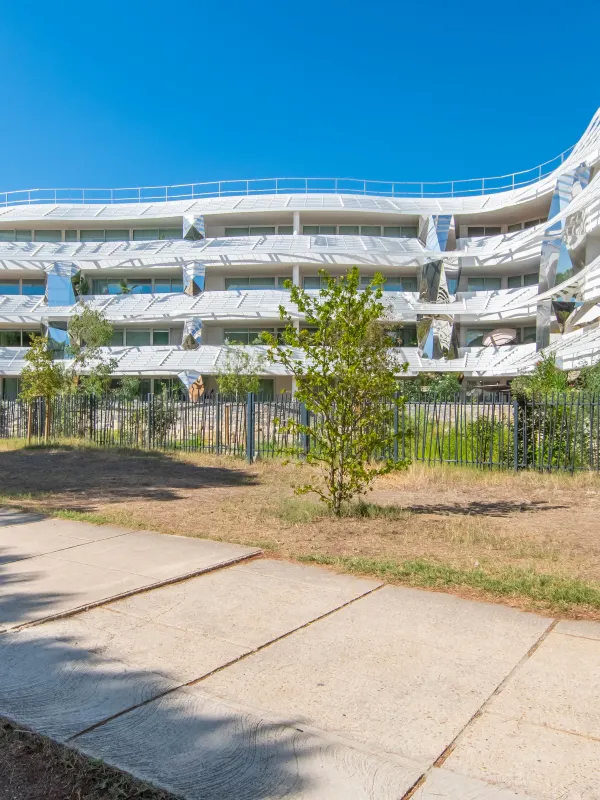 Visuel extérieur d'un logement de couleur blanc entouré d'arbre