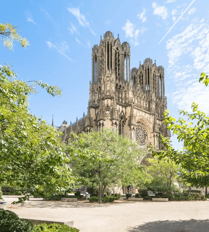 Vue majestueuse de la cathédrale Notre-Dame de Reims, joyau de l’architecture gothique et symbole fort de la ville. Entourée de verdure et baignée de lumière, elle incarne l’élégance et le dynamisme de Reims, ville du Grand-Est en plein essor.