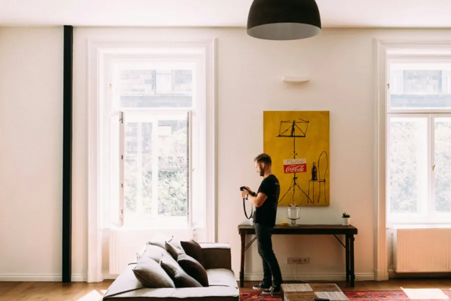 Homme dans son salon avec appareil photo