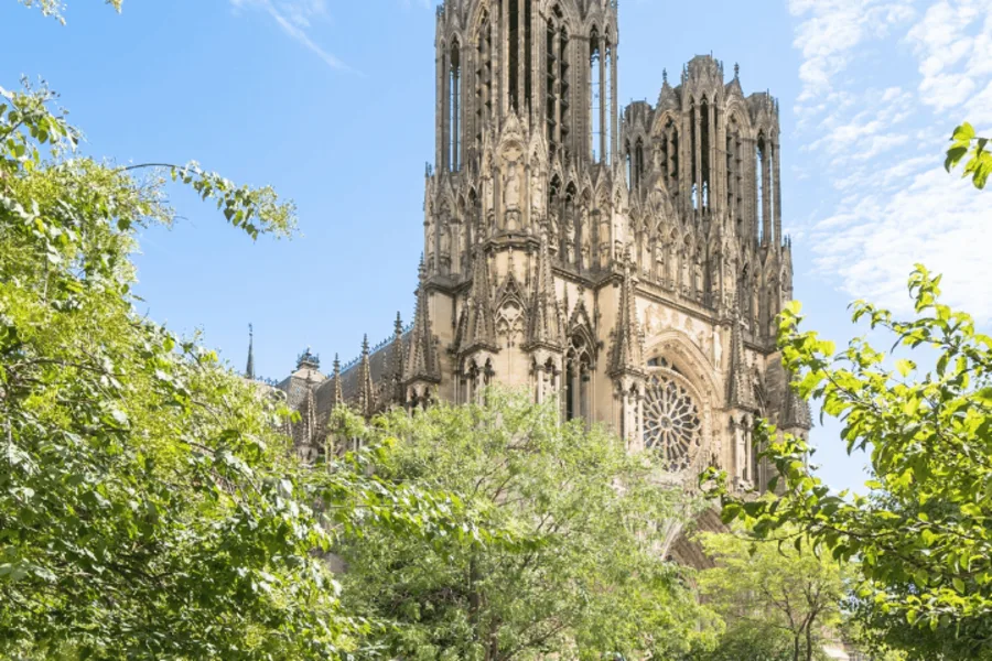 Vue majestueuse de la cathédrale Notre-Dame de Reims, joyau de l’architecture gothique et symbole fort de la ville. Entourée de verdure et baignée de lumière, elle incarne l’élégance et le dynamisme de Reims, ville du Grand-Est en plein essor.