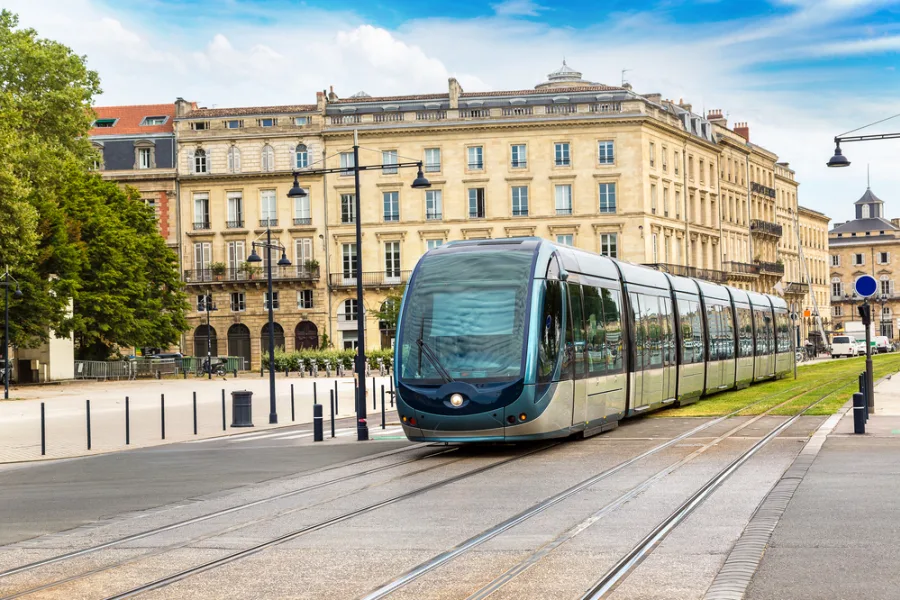 Tramway urbain moderne à Bordeaux lors d'une journée d'été.