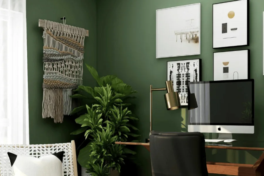 Un bureau avec des murs vert. Des plantes et un fauteuil pour un espace de travail.